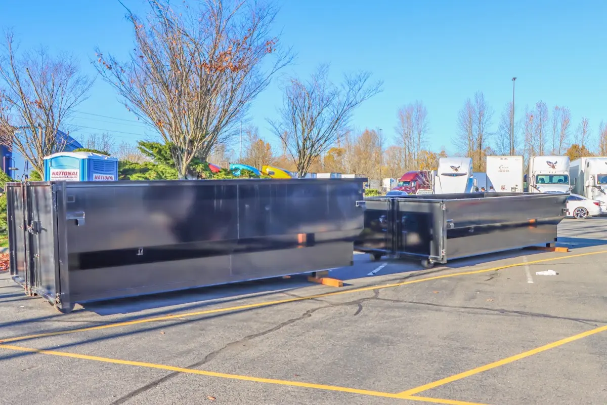 Professional dumpster rental service with roll-off container on residential driveway in New Bern